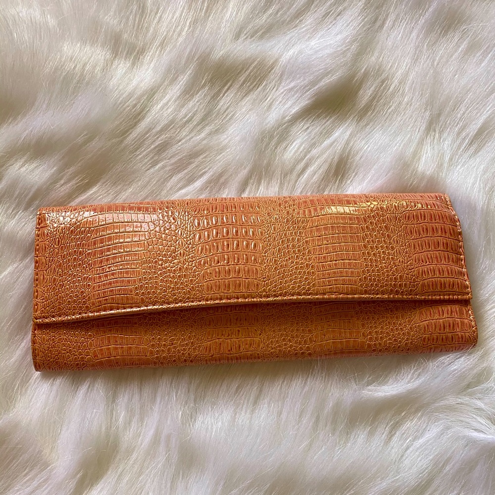 Coral colored faux snake skin clutch
